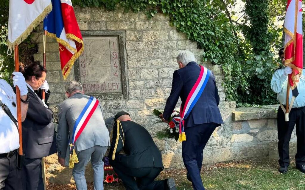 Le député Joël Bruneau dépose une gerbe de fleurs devant le monument commémoratif de Bomb Alley à Bretteville-sur-Odon