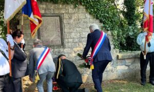 Le député Joël Bruneau dépose une gerbe de fleurs devant le monument commémoratif de Bomb Alley à Bretteville-sur-Odon